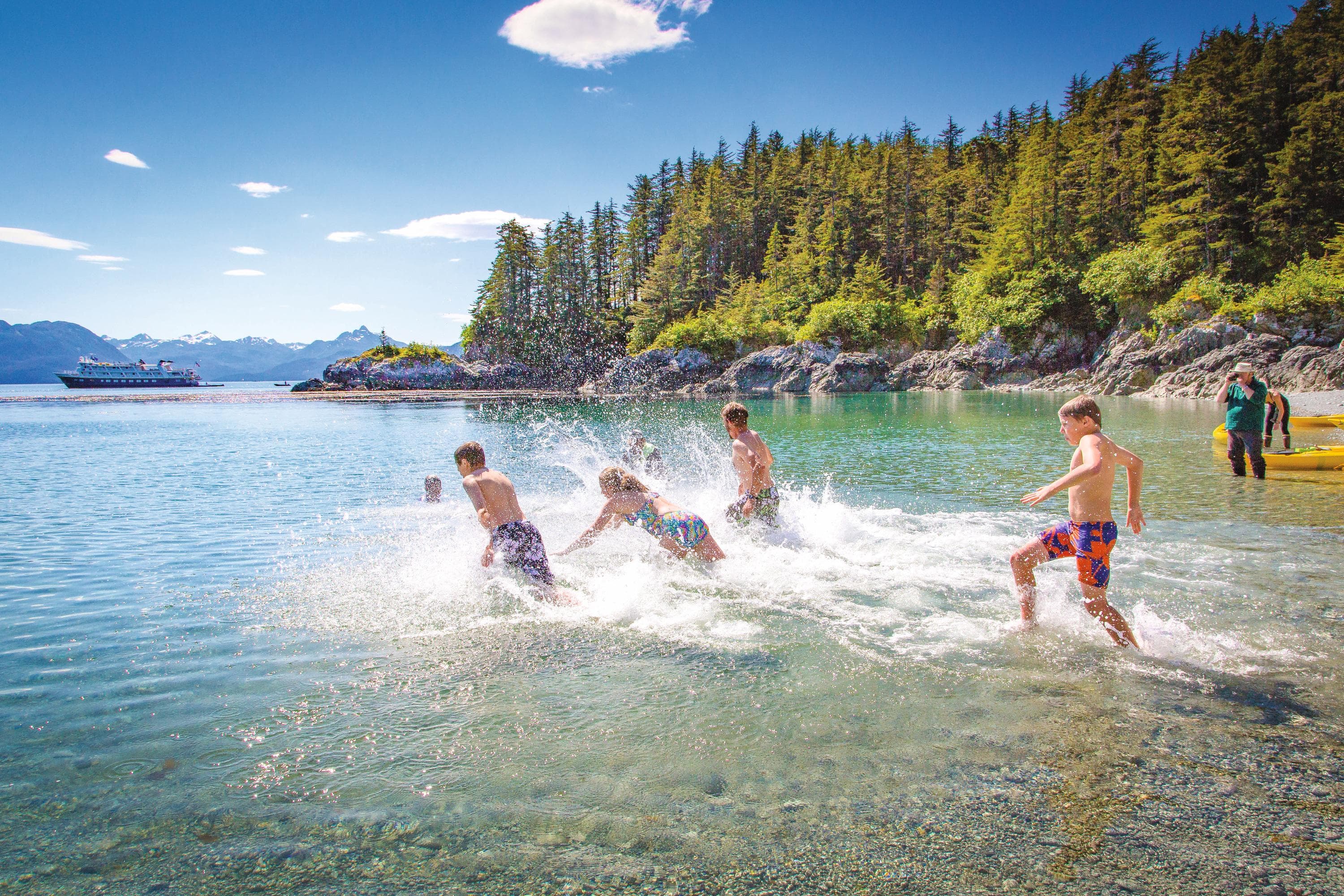 Young guests jumping into the brisk waters of Alaska, USA