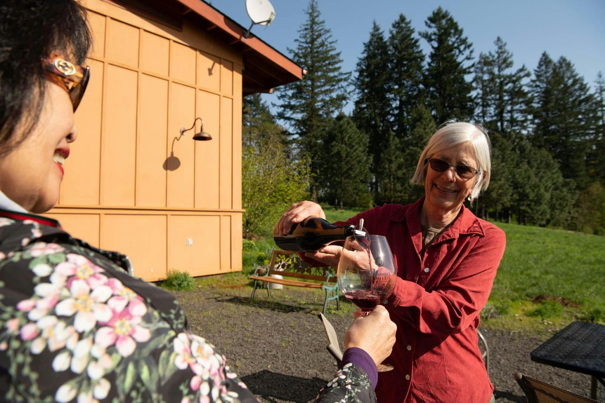 Owner of Winter's Hill Winery, Emily Gladhart, pouring wine for guests,  Dayton, Oregon